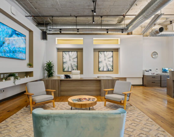 Office with hard wood floors.white walls, exposed ceiling, TV and lounge