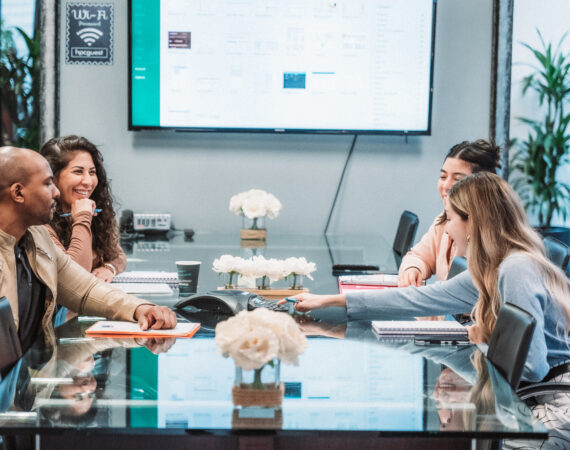 group in a meeting room pressing an answering machine