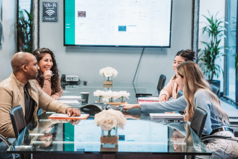 group in a meeting room pressing an answering machine