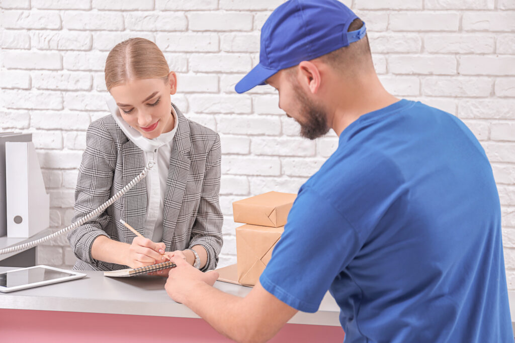 Female receptionist receiving parcels at workplace